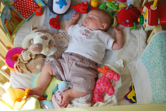Bambino che dorme con i giocattoli