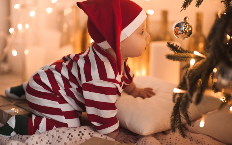 Bambino accanto all’albero di Natale