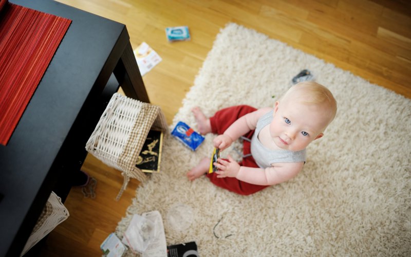Bambino in mezzo a una stanza disordinata