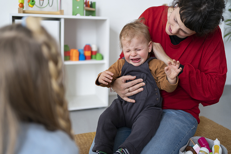 Bambino che piange in braccio