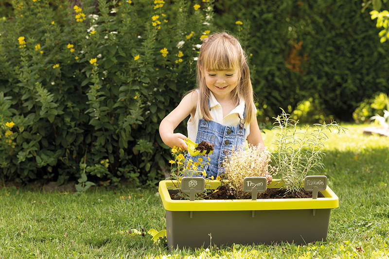La bambina coltiva erbe aromatiche